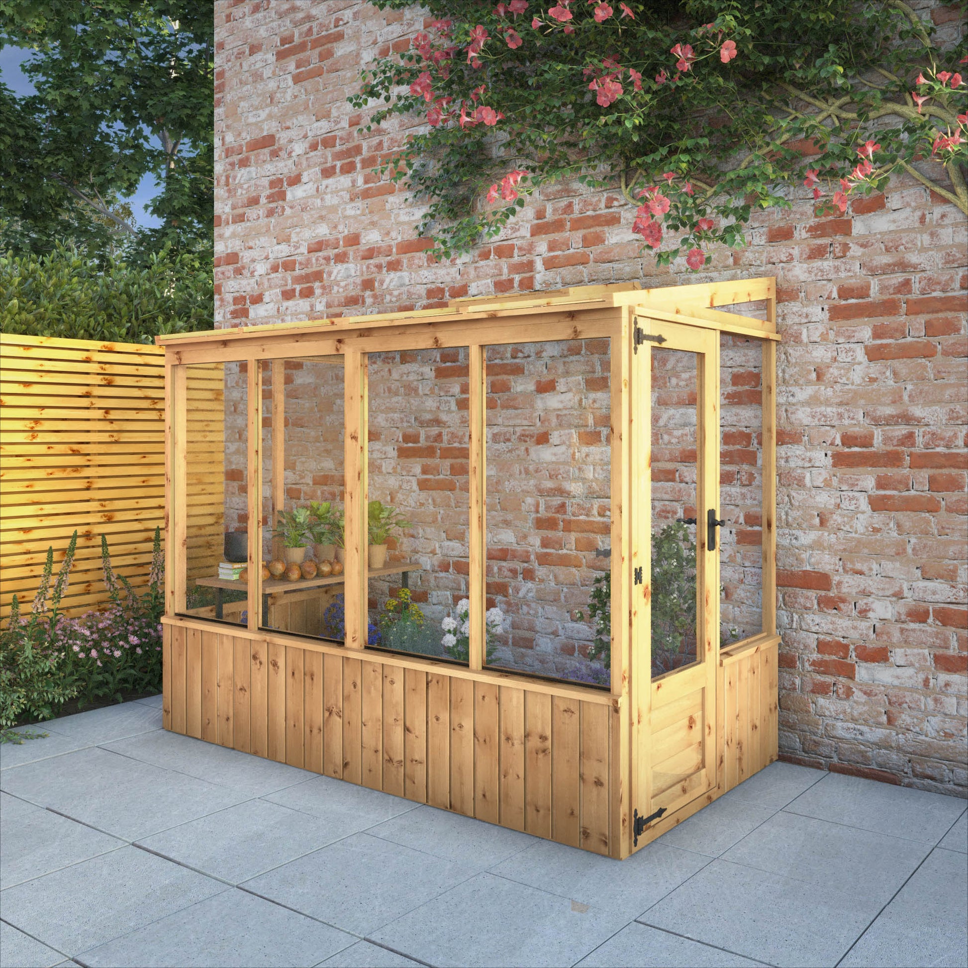 A lean-to greenhouse against a brick wall made from timber